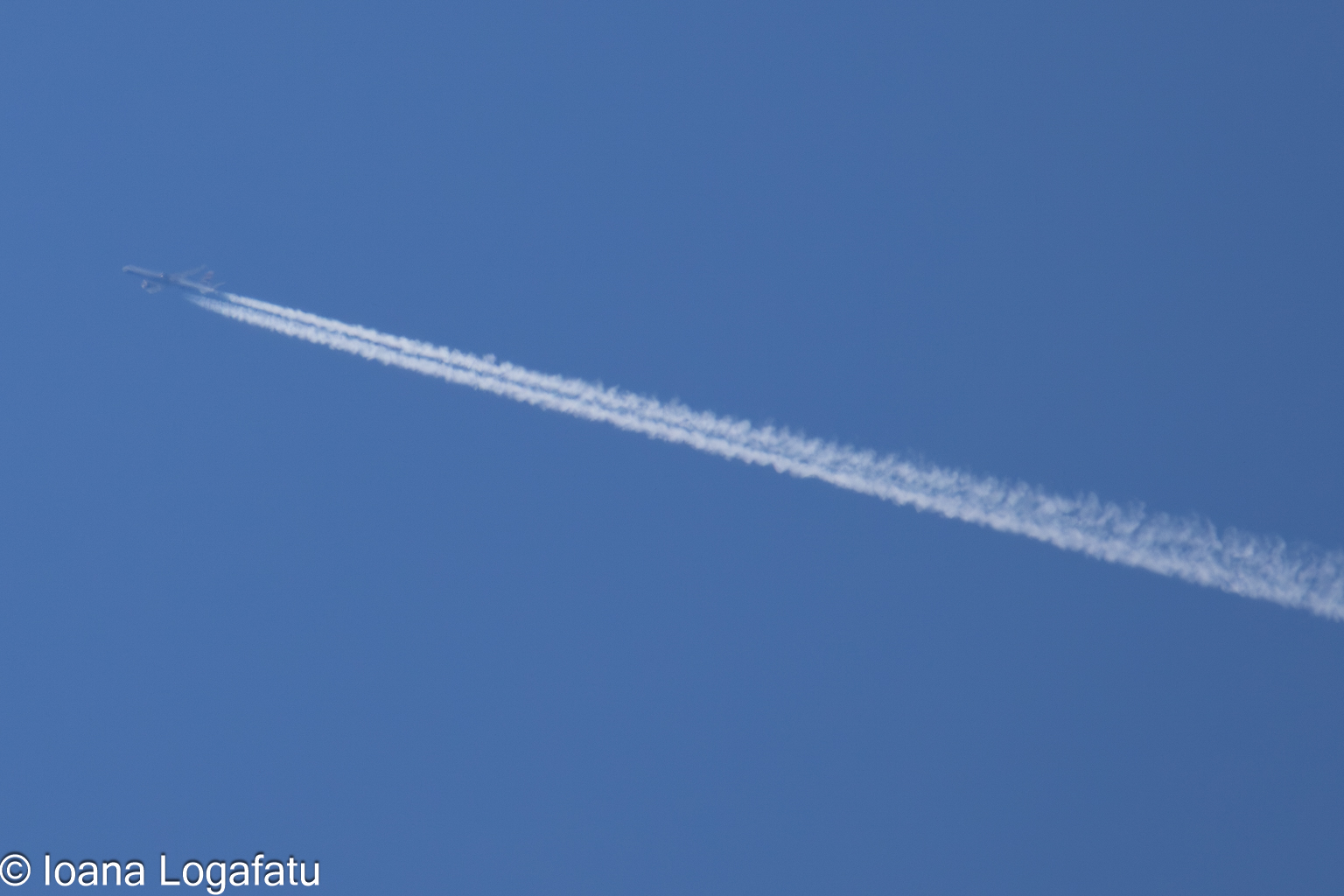Contrails tracing patterns in a clear blue sky